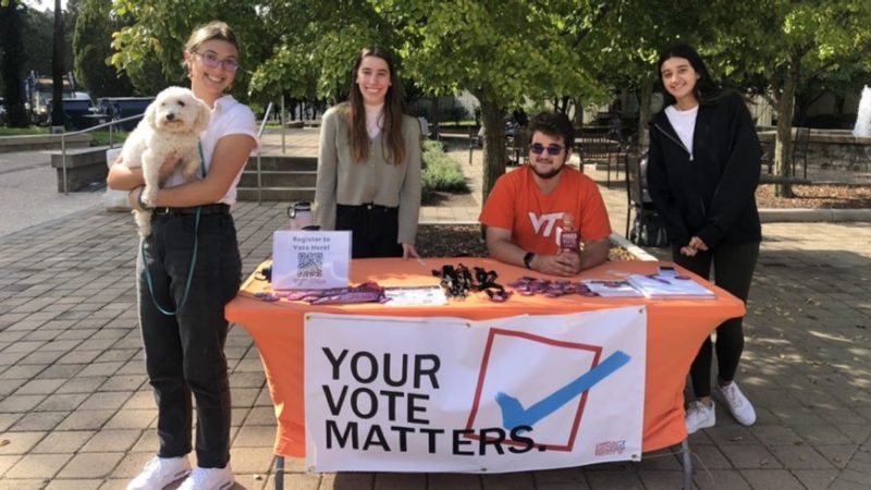 Students at a table promoting voting. 
